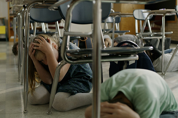 Image: School children practicing “Drop, Cover, and Hold On”