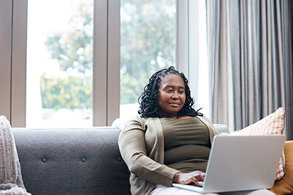 Image: Woman on couch with laptop