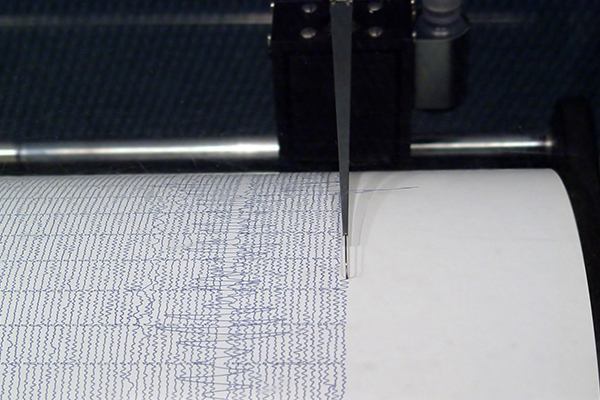Image: Seismograph making wave lines. When an earthquake occurs and the ground begins to shake, this shaking is recorded by an instrument called a seismograph.